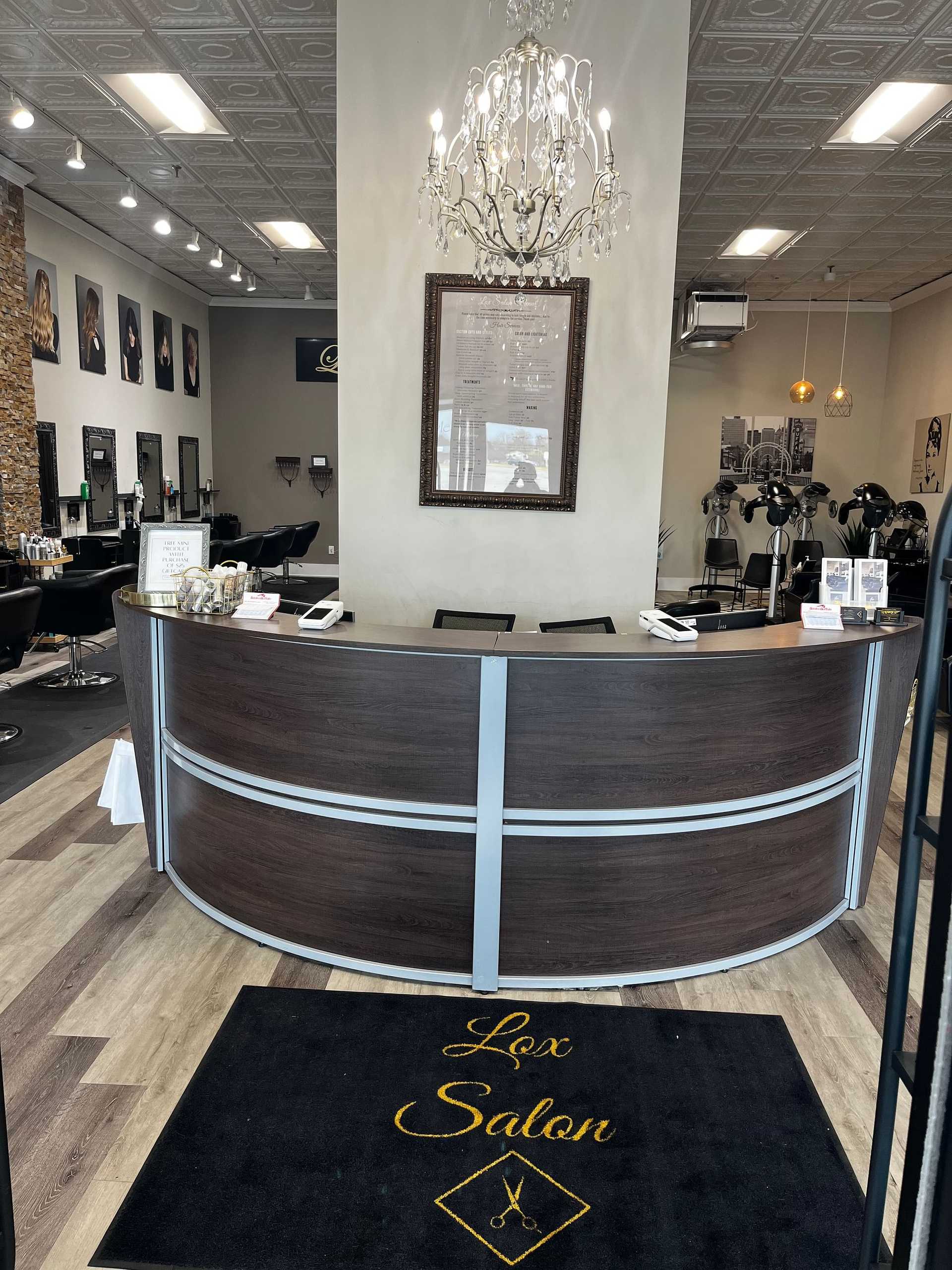 Elegant hair salon interior with reception desk and chandelier.